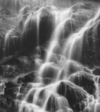 The water cascades gracefully over a series of jagged rocks, creating a soft, misty effect. The long exposure technique smooths the water's surface, giving it a dreamy, ethereal quality. Goat Waterfall is in Romania being located in the Fagaras Mountains in the South part of the Carpathians.